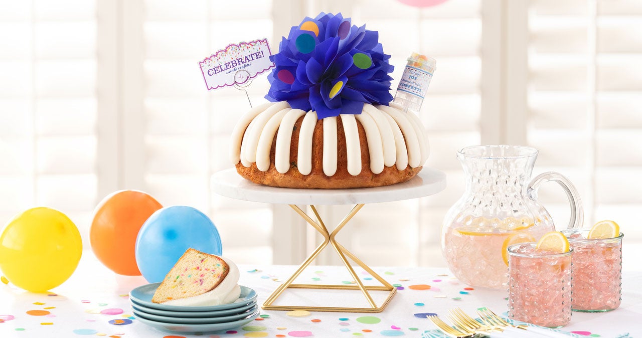 Celebrate Bundt Cake topped with a mini confetti-stickered bow and confetti popper - Shop Now