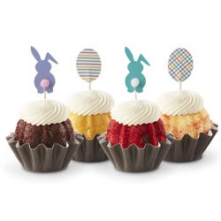 Mini Bundt cakes, each topped with a unique Easter-themed topper: two bunnies and two patterned eggs. 
