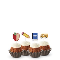 Carrot flavored mini Bundt cakes (Bundtinis®) topped with creamy white frosting, accompanied by school-themed toppers: a sliced apple, a pencil, a notebook, and a yellow school bus.