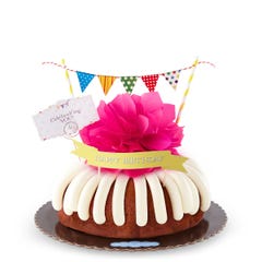 A bundt cake with a banner that says Happy Birthday, with party pennants with various dotted and lined designs. A card reads Cele'bundt'ing YOU!.