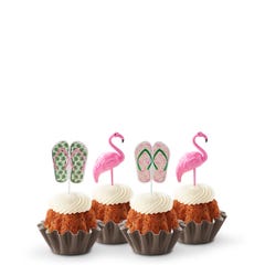 Mini bundt cakes decorated with a topper: from left to right, there's a pair of green tropical flip-flops, a pink flamingo, another pair of pink flip-flops with green straps, and another pink flamingo.