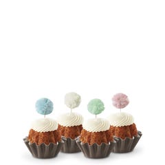 Cupcake-sized Bundt cakes topped with creamy white frosting. Each has a fluffy pom-pom topper in shades of sky blue, white, mint green, and soft rose.
