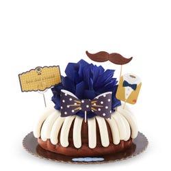 A bundt cake with frosting and topped with a bowtie and a moustache decoration. A card is attached to the cake and reads best dad a'round.
