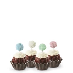 Cupcake-sized Bundt cakes topped with creamy white frosting. Each has a fluffy pom-pom topper in shades of sky blue, white, mint green, and soft rose.