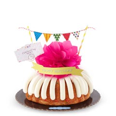 A bundt cake with a banner that says Happy Birthday, with party pennants with various dotted and lined designs. A card reads Cele'bundt'ing YOU!.