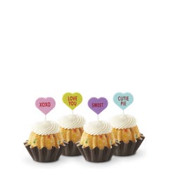 Mini Bundt cakes with white frosting, topped with conversation hearts in pink, lime, lavender, and light teal, displaying messages: XOXO, LOVE YOU, SWEET, and CUTIE PIE.