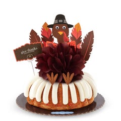 A large Confetti bundt cake with a chocolate colored bow in the center and a whimsical turkey cutout with 5 Gratitude Feathers. 