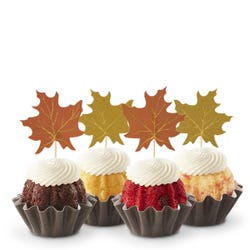 Cupcake-sized mini cakes with frosting and decorated with fall leaves toppers. 