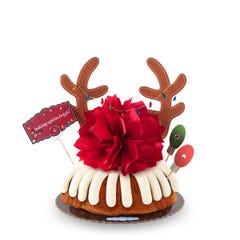 Holiday Gluten Free Chocolate Chip Cookie bundt cake decorated with reindeer antlers with Christmas lights running across the antlers. There are also two christmas lights with leds that light up. A card reads baking spirits bright.