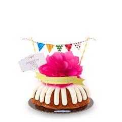 A bundt cake with a banner that says Happy Birthday, with party pennants with various dotted and lined designs. A card reads Cele'bundt'ing YOU!.