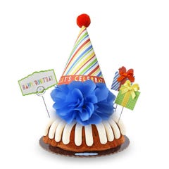 A bundt cake with frosting topped with a party hat that says Let's Celebrate. Two wrapped gift boxes are on the sides along with a card that reads Happy 'Bundt'day.