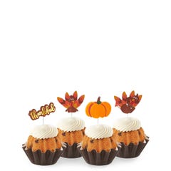 Bundtinis with a variety of fall themed toppers including turkeys and a pumpkin. 