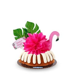 A Gluten-Free Chocolate Chip Cookie bundt cake decorated with a pink flamingo with tropical leaves. It also includes a card that reads Party in Paradise. 