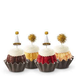 Mini Bundt cakes adorned with festive party hat toppers and golden pom-poms themed for a New Year's celebration.
