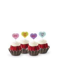 Mini Bundt cakes with white frosting, topped with conversation hearts in pink, lime, lavender, and light teal, displaying messages: XOXO, LOVE YOU, SWEET, and CUTIE PIE.