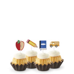 Vanilla flavored mini Bundt cakes (Bundtinis®) topped with creamy white frosting, accompanied by school-themed toppers: a sliced apple, a pencil, a notebook, and a yellow school bus.