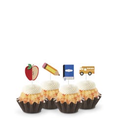 White Chocolate Raspberry flavored mini Bundt cakes (Bundtinis®) topped with creamy white frosting, accompanied by school-themed toppers: a sliced apple, a pencil, a notebook, and a yellow school bus.