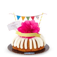 A bundt cake with a banner that says Happy Birthday, with party pennants with various dotted and lined designs. A card reads Cele'bundt'ing YOU!.