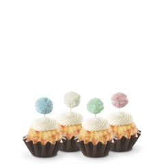 Cupcake-sized Bundt cakes topped with creamy white frosting. Each has a fluffy pom-pom topper in shades of sky blue, white, mint green, and soft rose.